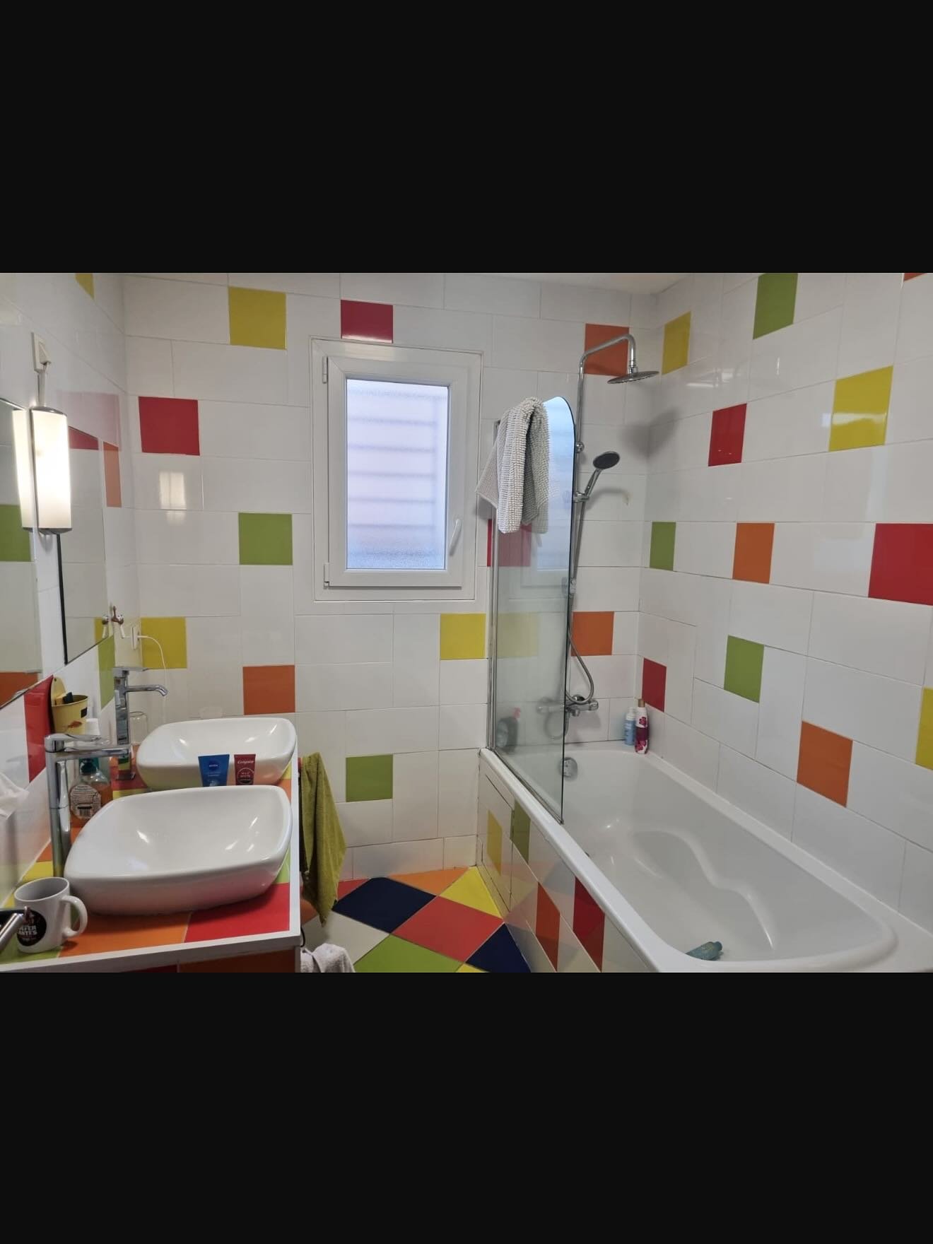 Salle de bain avant rénovation avec carrelage coloré et baignoire
